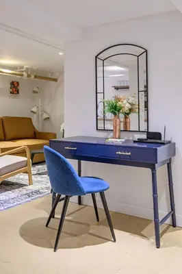 a blue desk with a blue chair and a mirror at 20 Mins to Times Sq. EWR | Cozy Apartment | Sleeps 4 in Jersey City