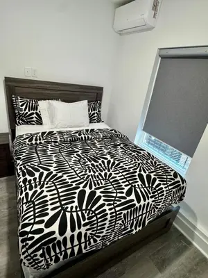 a black and white bed in a white room at Cozy Retreat Near EWR with NYC access in Newark