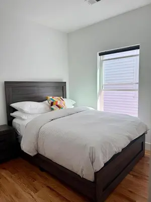 a bedroom with a large bed and a window at Cozy Retreat Near EWR with NYC access in Newark