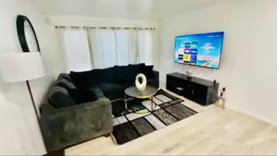 a living room with a couch and a table at Cozy Home 3BR-2Bath near EWR NYC DreamMall MetLife in Newark