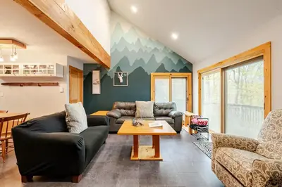 a living room with couches and a table at Ski-InandSki-Out Camelback Mtn Retreat with Hot Tub in Tannersville
