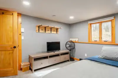 a bedroom with a bed and a flat screen tv at Ski-InandSki-Out Camelback Mtn Retreat with Hot Tub in Tannersville