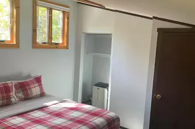 a bedroom with a bed with a red plaid blanket at Ski-InandSki-Out Camelback Mtn Retreat with Hot Tub in Tannersville