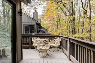 a porch with chairs and tables on a house at Ski-InandSki-Out Camelback Mtn Retreat with Hot Tub in Tannersville