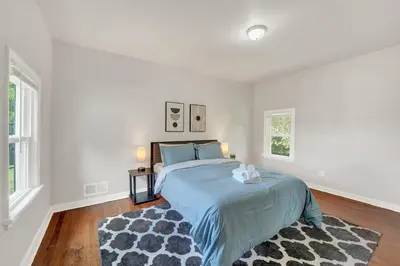 a white bedroom with a bed and a rug at Spacious 5-Bed Retreat in Charming Kennett Square in Kennett Square