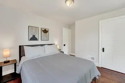 a white bedroom with a large bed and two lamps at Spacious 5-Bed Retreat in Charming Kennett Square in Kennett Square