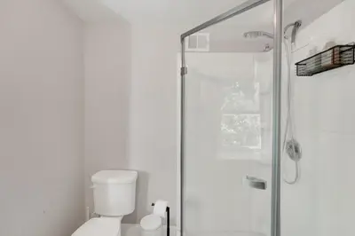 a white bathroom with a shower and a toilet at Spacious 5-Bed Retreat in Charming Kennett Square in Kennett Square