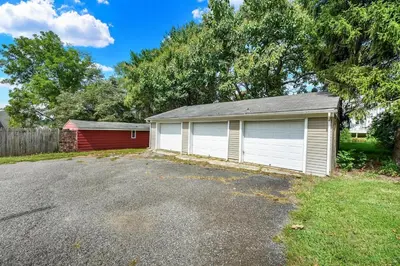 a garage with a red and white house at Spacious 5-Bed Retreat in Charming Kennett Square in Kennett Square