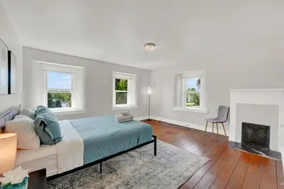 a white bedroom with a bed and a fireplace at Spacious 5-Bed Retreat in Charming Kennett Square in Kennett Square