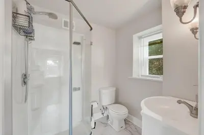 a bathroom with a shower and a toilet and a sink at Spacious 5-Bed Retreat in Charming Kennett Square in Kennett Square