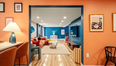 a living room with orange walls and an open door at Sleeps 13 Private Sauna Hot Tub Game Room in Thornhurst