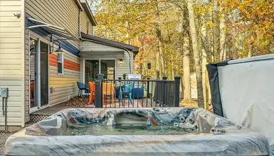 a hot tub in a yard next to a house at Sleeps 13 Private Sauna Hot Tub Game Room in Thornhurst