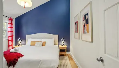 a bedroom with a white bed with a blue wall at Sleeps 13 Private Sauna Hot Tub Game Room in Thornhurst