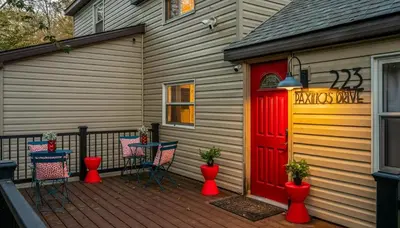a deck with a red door and a table and chairs at Sleeps 13 Private Sauna Hot Tub Game Room in Thornhurst