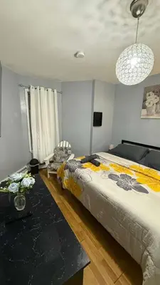 a bedroom with a large bed and a table at New 3 BR Apt in Elizabeth Railroad Style Path Train Bus Hospital EWR Airport NJ Manhattan NYC in Elizabeth