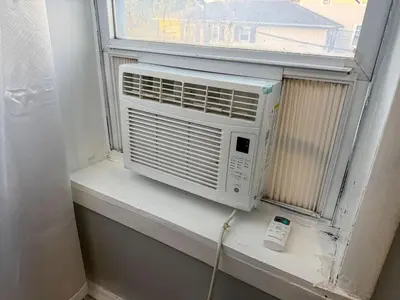 a air conditioner sitting on a window sill at New 3 BR Apt in Elizabeth Railroad Style Path Train Bus Hospital EWR Airport NJ Manhattan NYC in Elizabeth