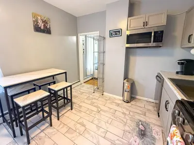 a kitchen with a table and two stools in it at New 3 BR Apt in Elizabeth Railroad Style Path Train Bus Hospital EWR Airport NJ Manhattan NYC in Elizabeth
