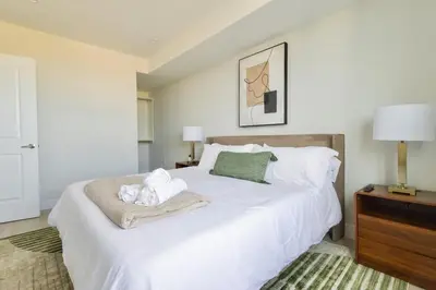 a bedroom with a white bed with towels on it at Luxe Loft 15 Min from NYC with City View & Gym in Jersey City