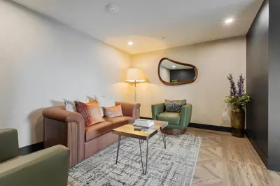 a living room with a couch and two chairs at Sleek Loft 15 Min from NYC with Manhattan View in Jersey City