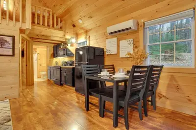 a kitchen with a table and chairs in a cabin at Mountain Bliss Cottage