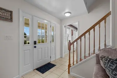 a hallway with a white door and a staircase at Peaceful Valley Retreat in Elliottsburg