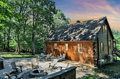 a small log cabin with chairs and a table at Pine View Cottage in Elliottsburg