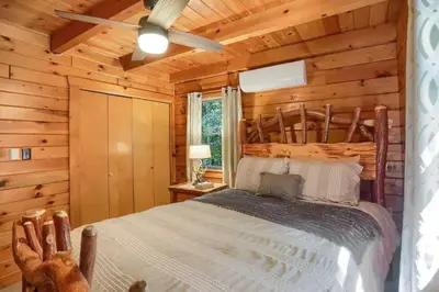 a bedroom with a bed in a log cabin at Pine View Cottage in Elliottsburg