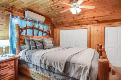 a bedroom with a bed and a ceiling fan at Pine View Cottage in Elliottsburg