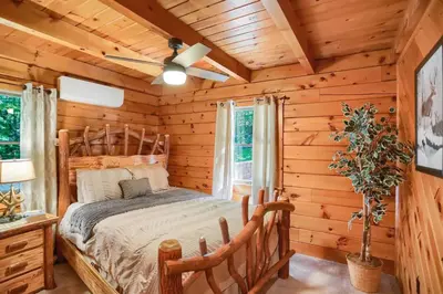 a bedroom with a bed in a log cabin at Pine View Cottage in Elliottsburg