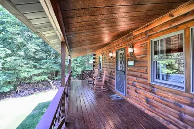 a front porch of a wooden cabin with a door at Pine View Cottage in Elliottsburg