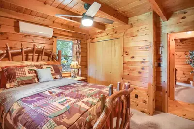 a bedroom with a bed in a log cabin at Pine View Cottage in Elliottsburg