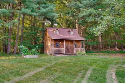 a small log cabin in the middle of a yard at Ridgetop Cabin in Elliottsburg