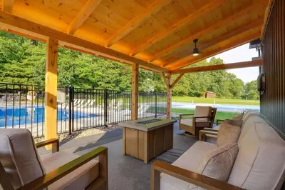 a screened in porch with couches and a table at Ridgetop Cabin in Elliottsburg