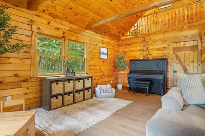 a living room with a piano in a log cabin at Ridgetop Cabin in Elliottsburg
