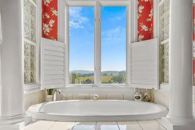 a bath tub in a bathroom with windows at Willow Brook Mansion in Millerstown