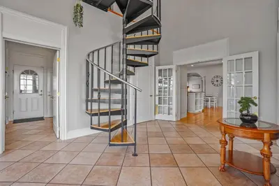 a spiral staircase in a living room with a table at Willow Brook Mansion in Millerstown