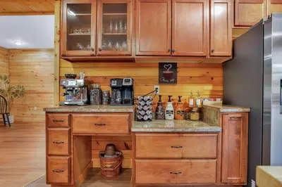 a kitchen with wooden cabinets and a counter top at Grateful Acres Cabin