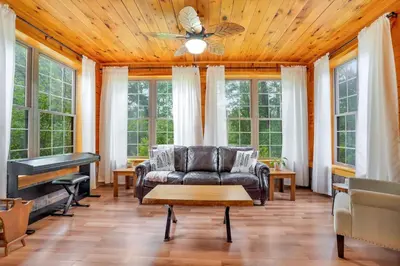 a living room with a couch and a piano at Grateful Acres Cabin