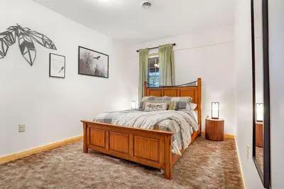 a bedroom with a wooden bed and a mirror at Grateful Acres Cabin