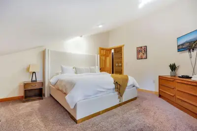 a bedroom with a large white bed and a television at Grateful Acres Cabin