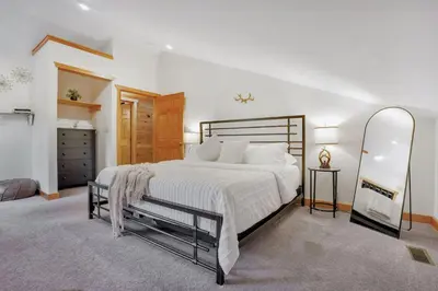 a bedroom with a large bed and a mirror at Grateful Acres Cabin