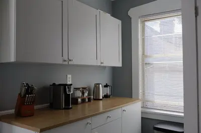 a kitchen with white cabinets and a wooden counter top at Cozy Home, 19m to NYC, 10m to American Dream in Wallington
