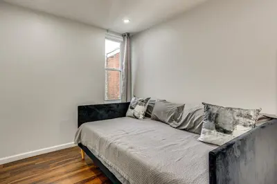 a couch in a room with a window at 3-Story Rowhouse with Patio! 5 Mi to Center City in Philadelphia