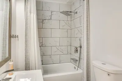 a white bathroom with a tub and a sink at 3-Story Rowhouse with Patio! 5 Mi to Center City in Philadelphia