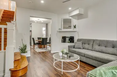a living room with a couch and a table at 3-Story Rowhouse with Patio! 5 Mi to Center City in Philadelphia
