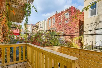a wooden balcony with a wooden bench on it at 3-Story Rowhouse with Patio! 5 Mi to Center City in Philadelphia