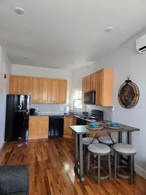 a kitchen with wooden cabinets and a table with stools at The Harrison in Harrison