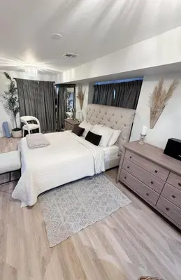 a bedroom with a large white bed and a dresser at New York City views! in Kearny