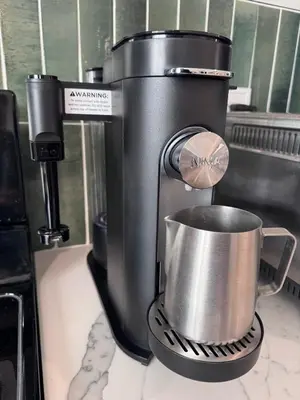 a coffee maker with a cup on a counter at New York City views! in Kearny