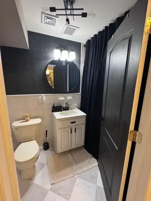 a bathroom with a toilet and a sink and a mirror at New York City views! in Kearny
